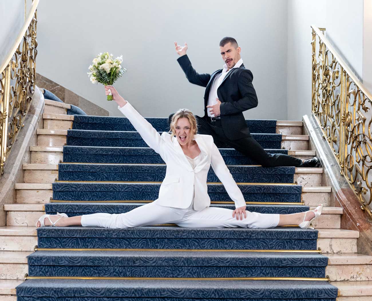 Eine Braut macht ein Spagat auf der Treppe und trägt dabei Schuhe von Werner Kern. 