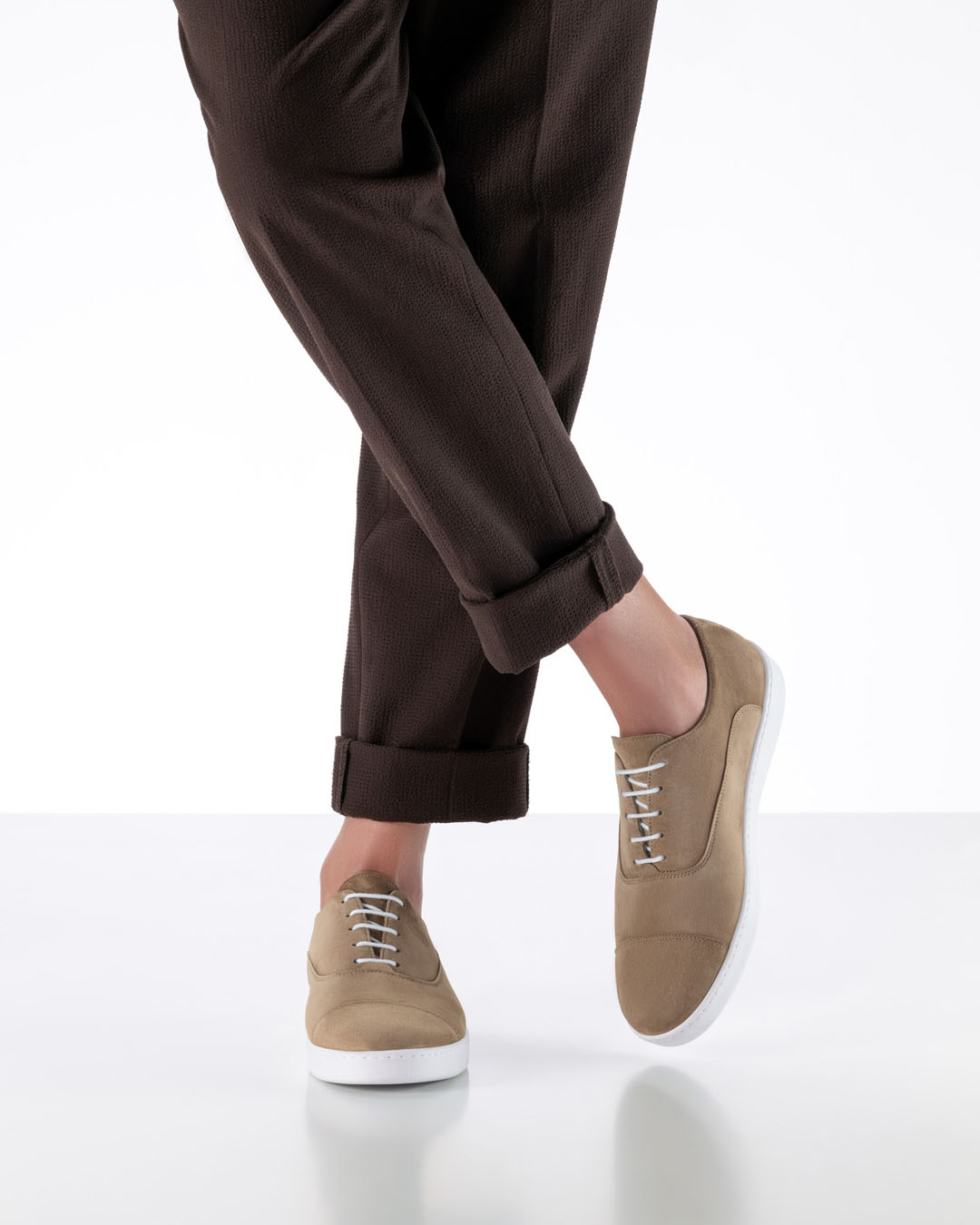 Herrentanzschuh in beigem Leder und weißer Sneakersohle von Werner Kern getragen mit dunkelbrauner Stoffhose