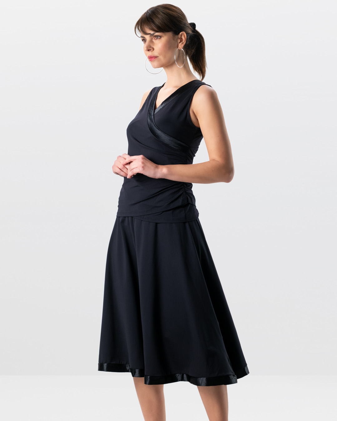 Modell im Studio trägt Tanztop Sira in Kombination mit dem schwarzen, langen Tanzrock Sari in schwarz