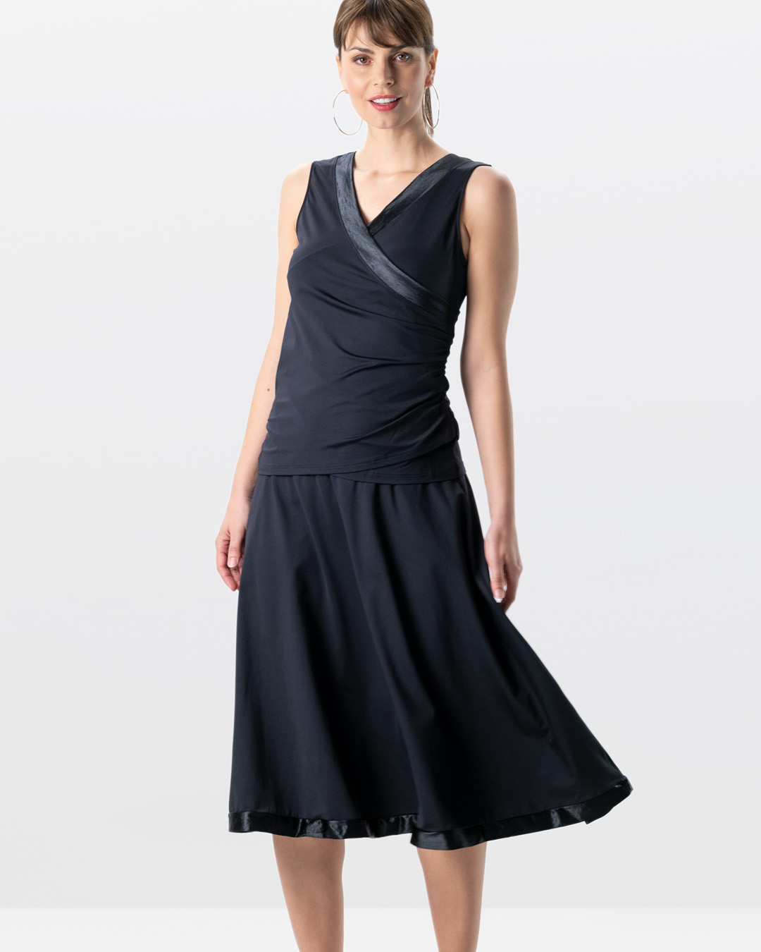 Modell im Studio trägt Tanztop Sira in Kombination mit dem schwarzen, langen Tanzrock Sari in schwarz